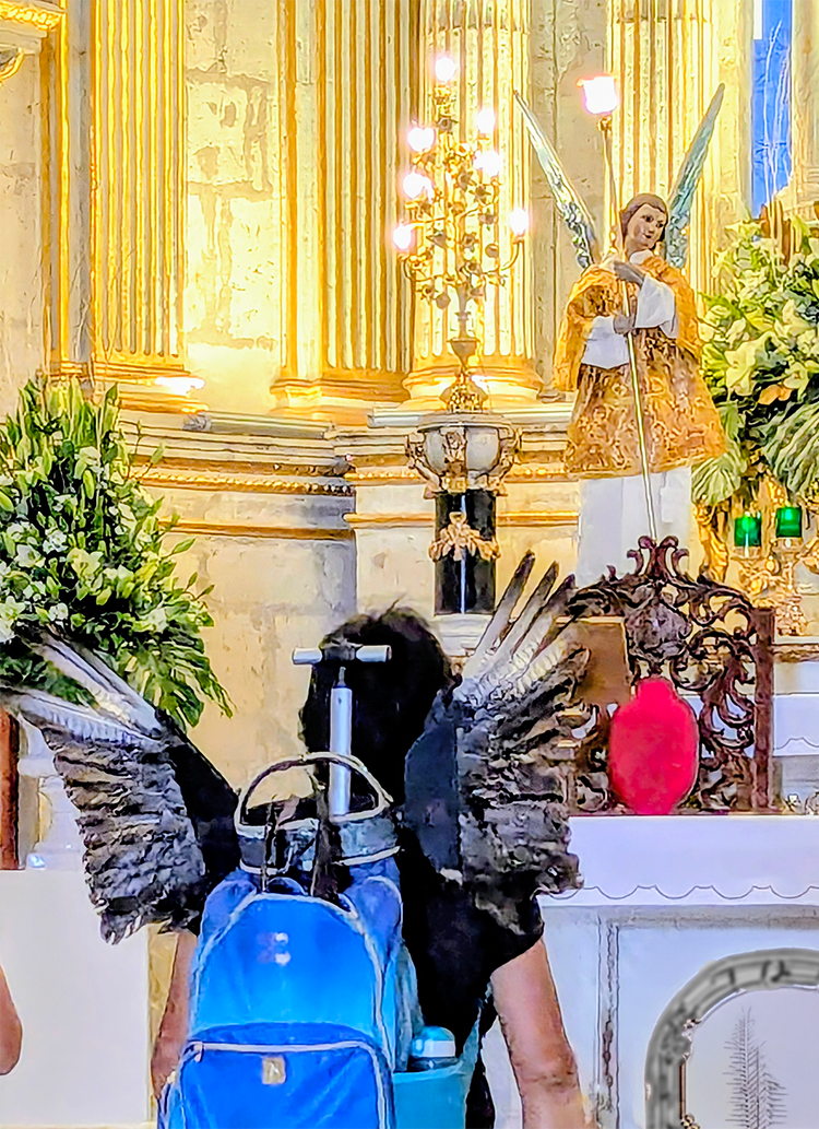native american dancer with feathered wings before feathered angels in basilica